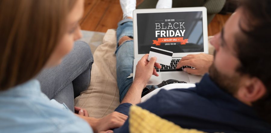 Man and Woman looking at Black Friday Deals while holding a credit card