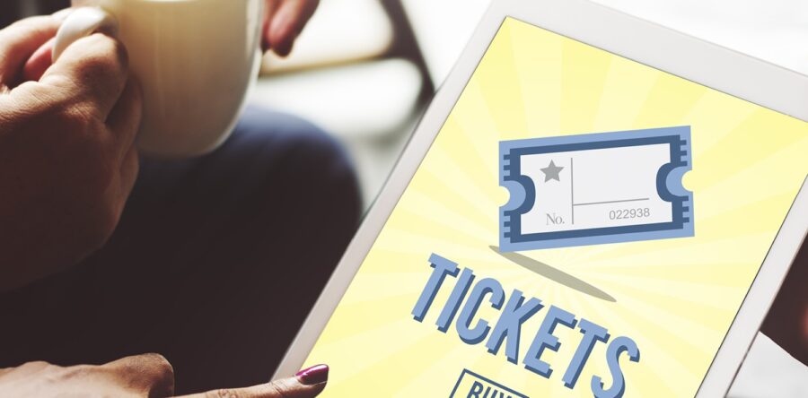 A person holding a piece of paper that says tickets on it with a picture of a ticket
