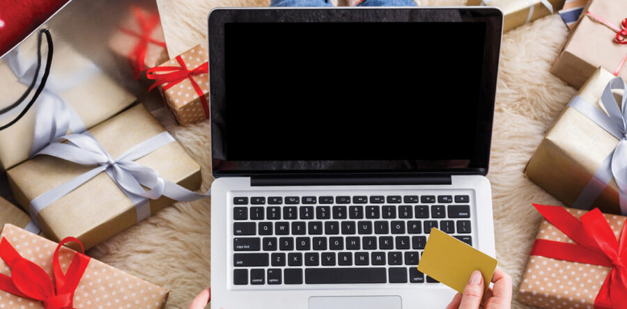Laptop with person holding a credit / Debit Card