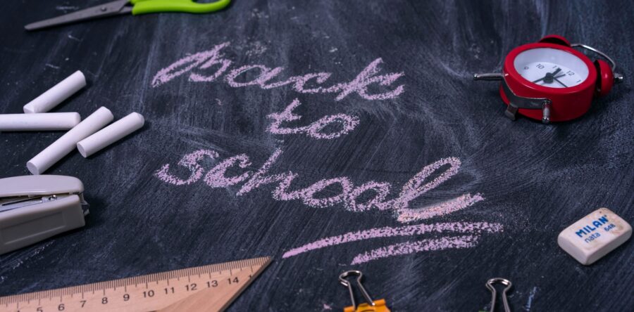 A Chalkboard that reads Back to school in pink chalk