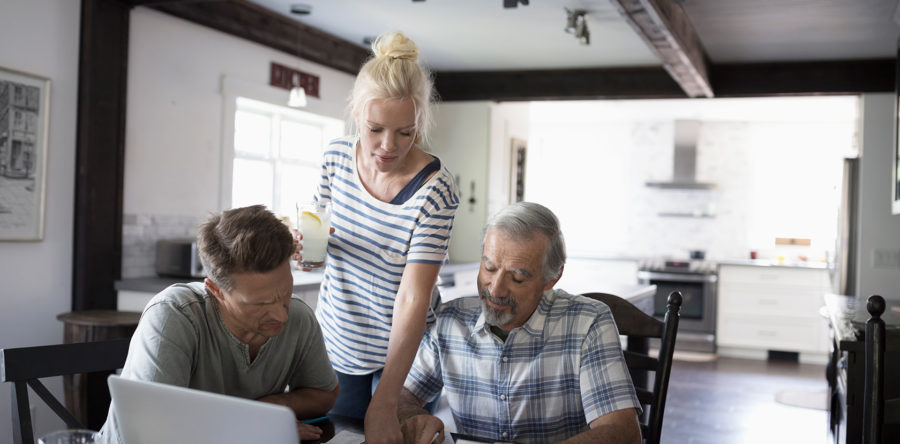 Woman pointing out something to older man and adult man