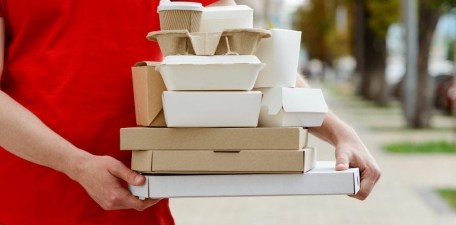 Person holding many food boxes delivering them