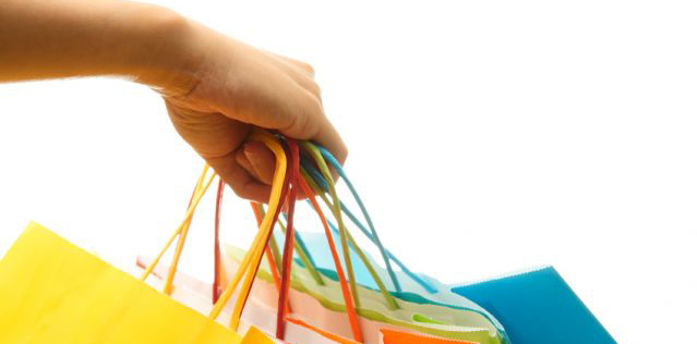 Person holding shopping bags of various colors