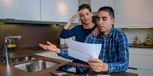 Couple looking at bills together looking stressed