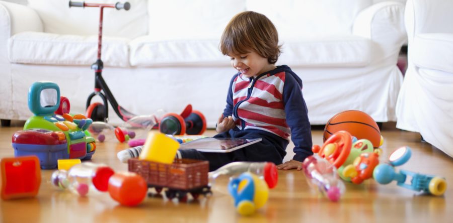 Kid surrounded by Toys sitting on the floor