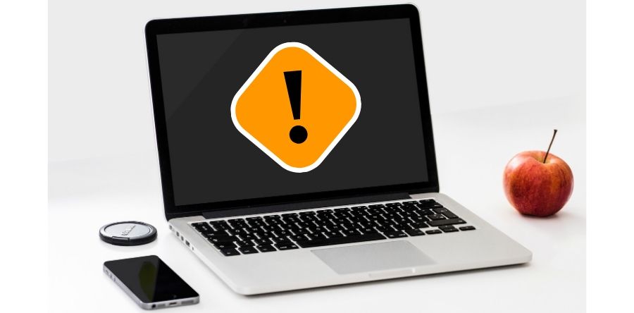 Laptop with apple next to it along with a phone. The Laptop is displaying a caution icon
