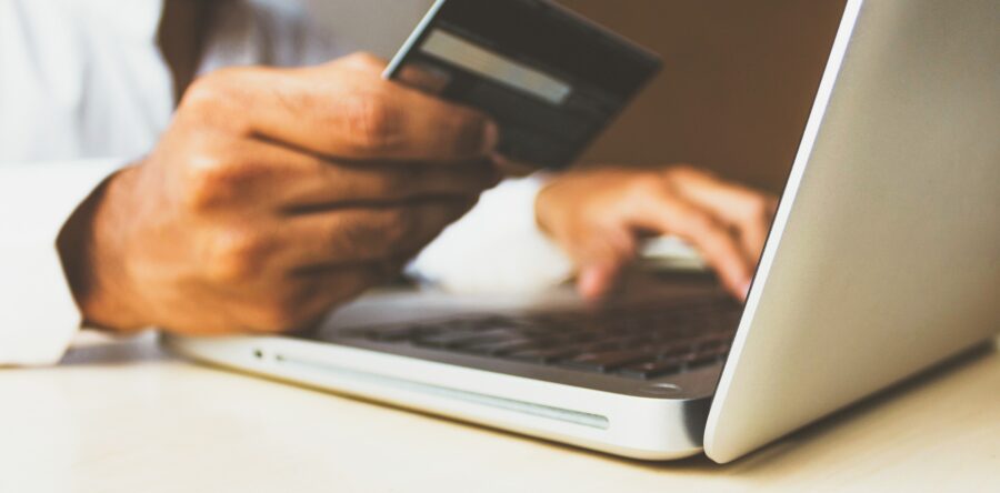 Person typing in credit card information into a laptop