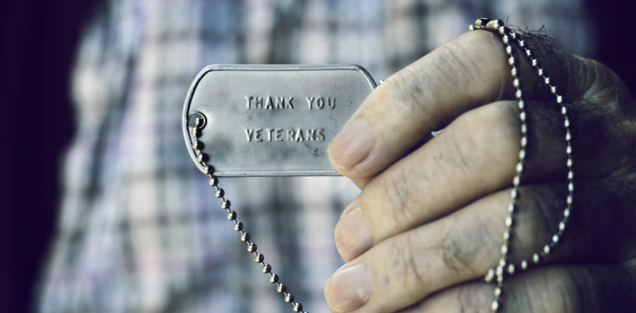 A person holding a dog tag that reads 