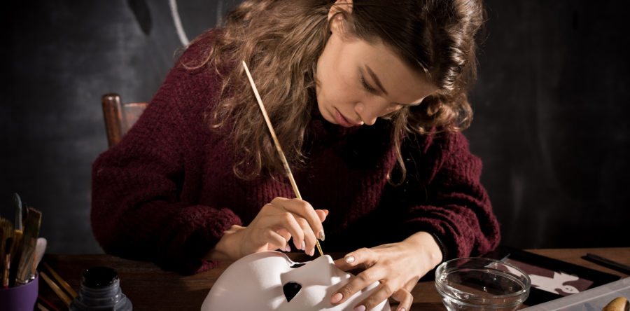 Girl painting a white mask