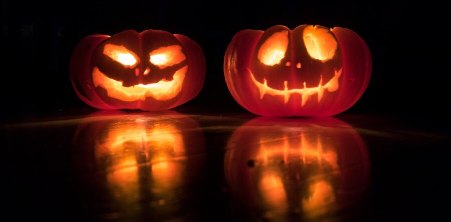 Two Jack-O-Lanterns at Night, glowing with a reflection