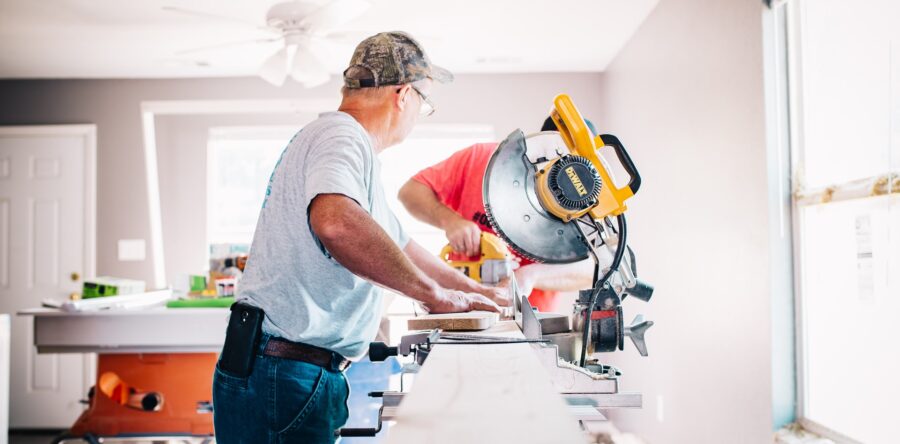 Carpenter using a miter saw to cut a wooden board