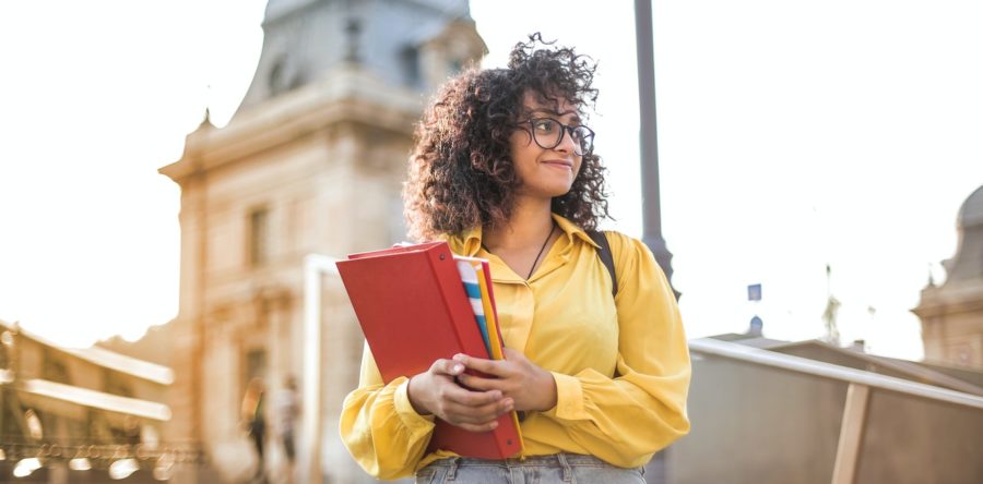 Woman smiling while carrying books