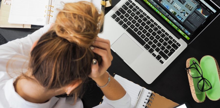 Woman stressed out while looking at her laptop